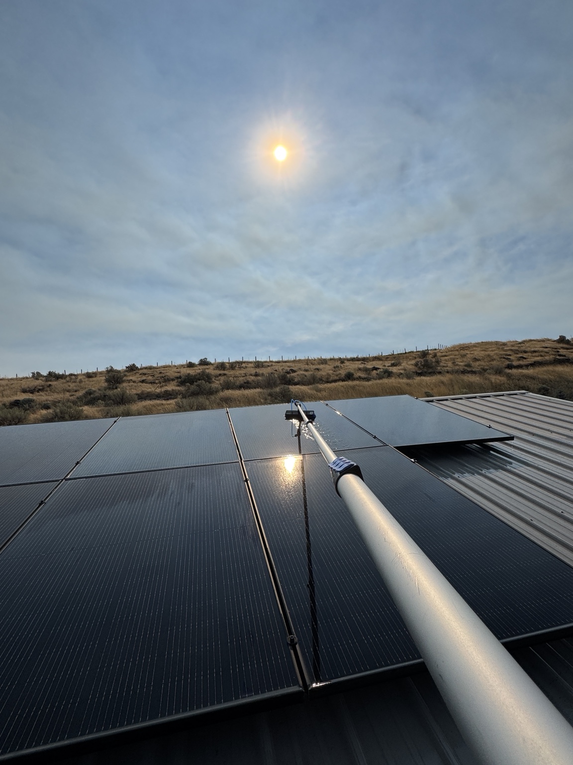 Water-fed brush cleaning solar panels